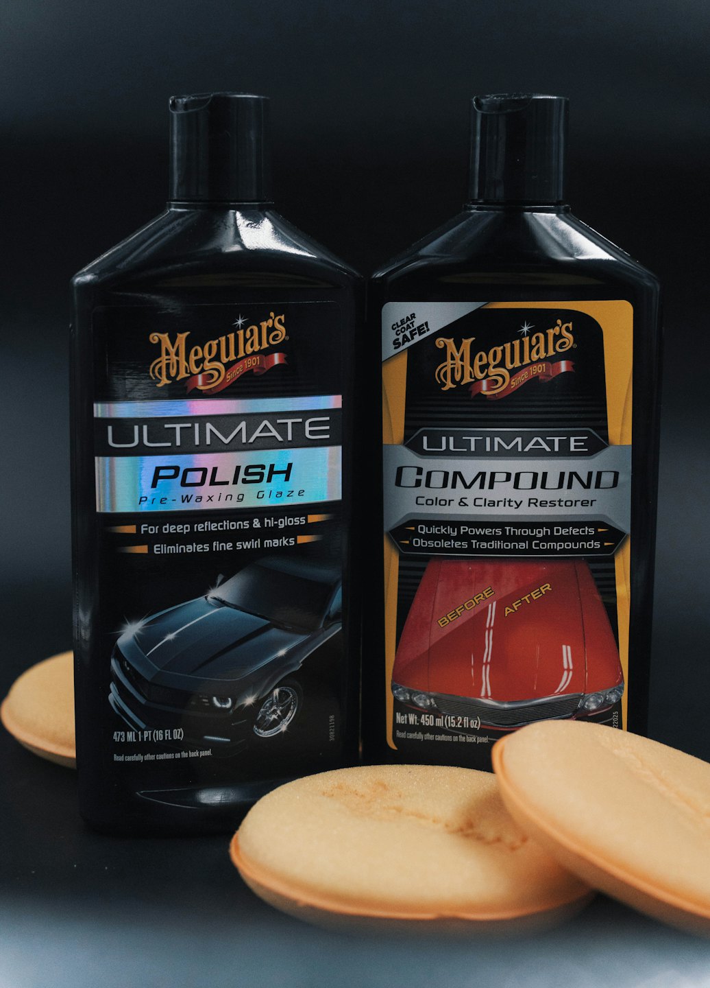 İki siyah Meguiar's araba bakım şişesi ve turuncu parlatma süngeri.
